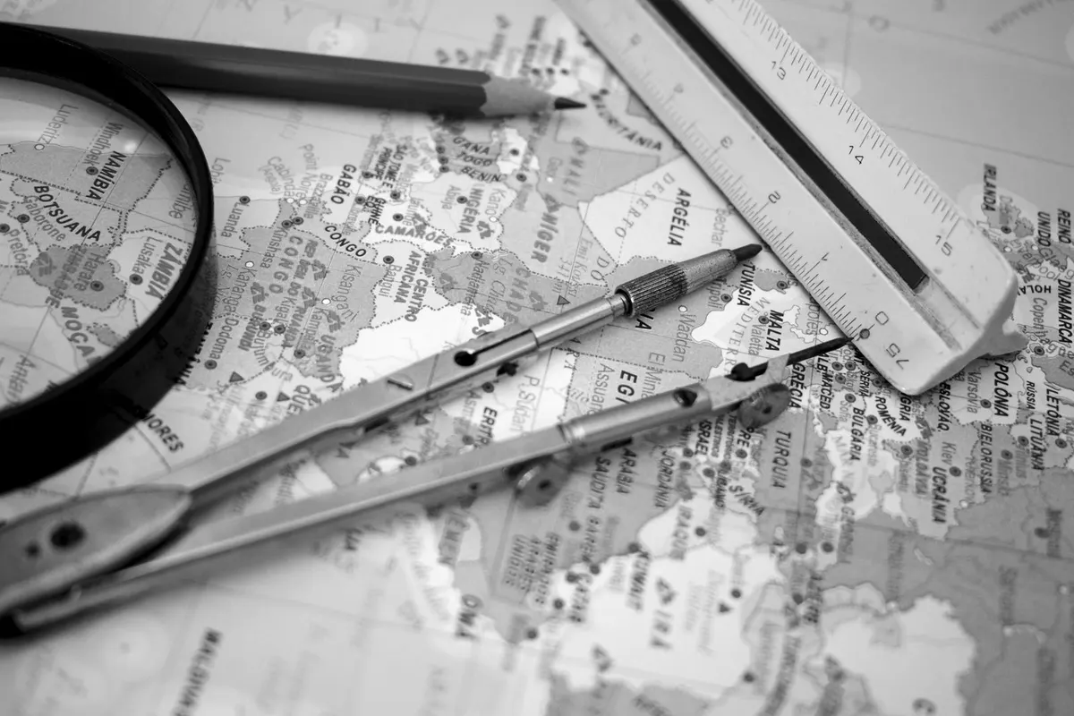Map with a drawing compass, ruler and magnifier